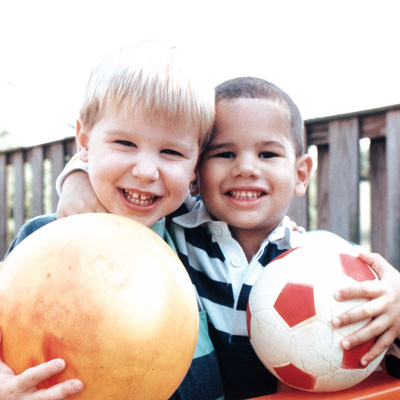 two kids with soccer balls