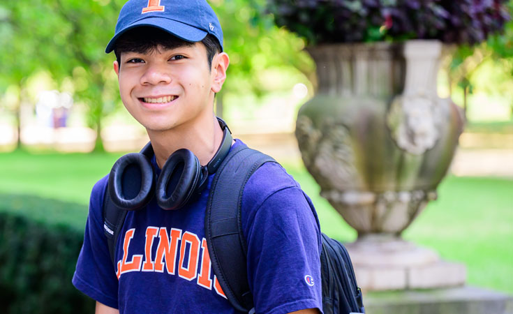 student with headphones and Illinois hat and shirt