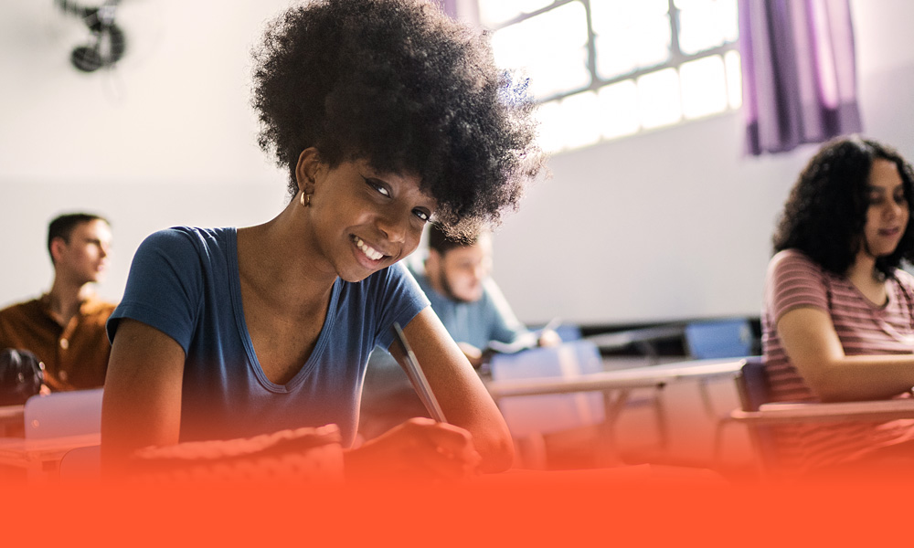 young and eager high school student smiling in class