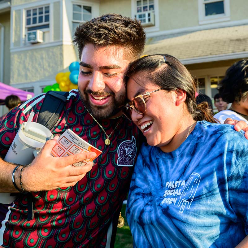 friends smile and embrace at a welcome event