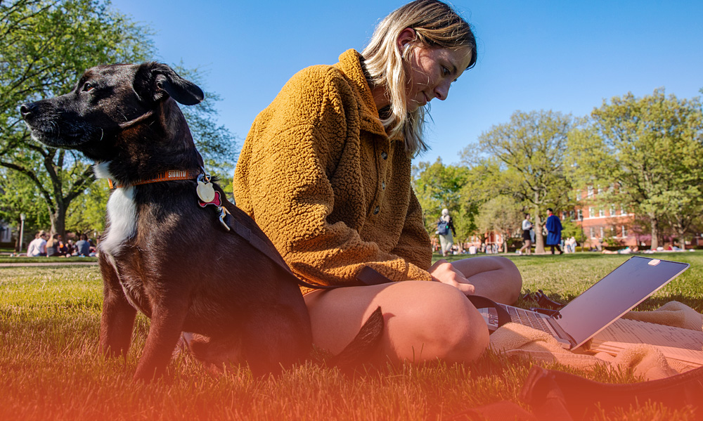 organized student planning out her week while on the Quad with her dog