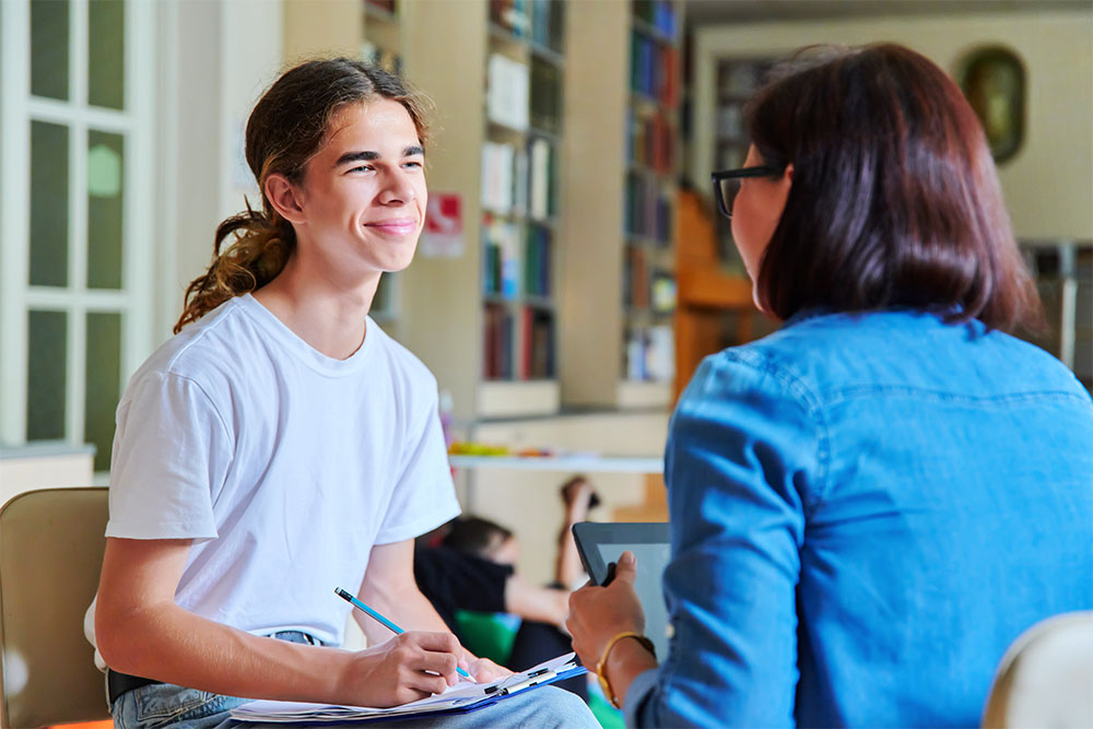 high school counselor meeting with one of their students, one-on-one