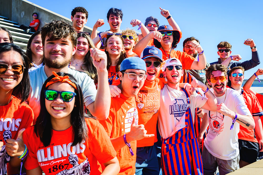 Block I student fans in orange and blue celebrate the Fighting Illini football team at Gies Memorial Stadium
