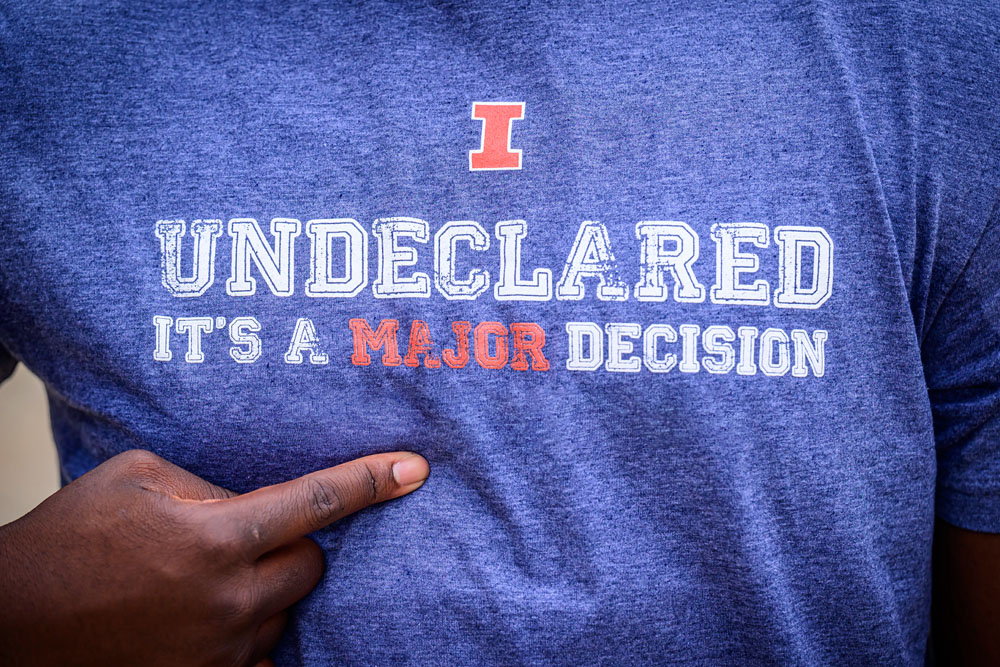 closeup of Exploratory Studies student pointing at their shirt which reads, "Undeclared: It's a Major Decision"