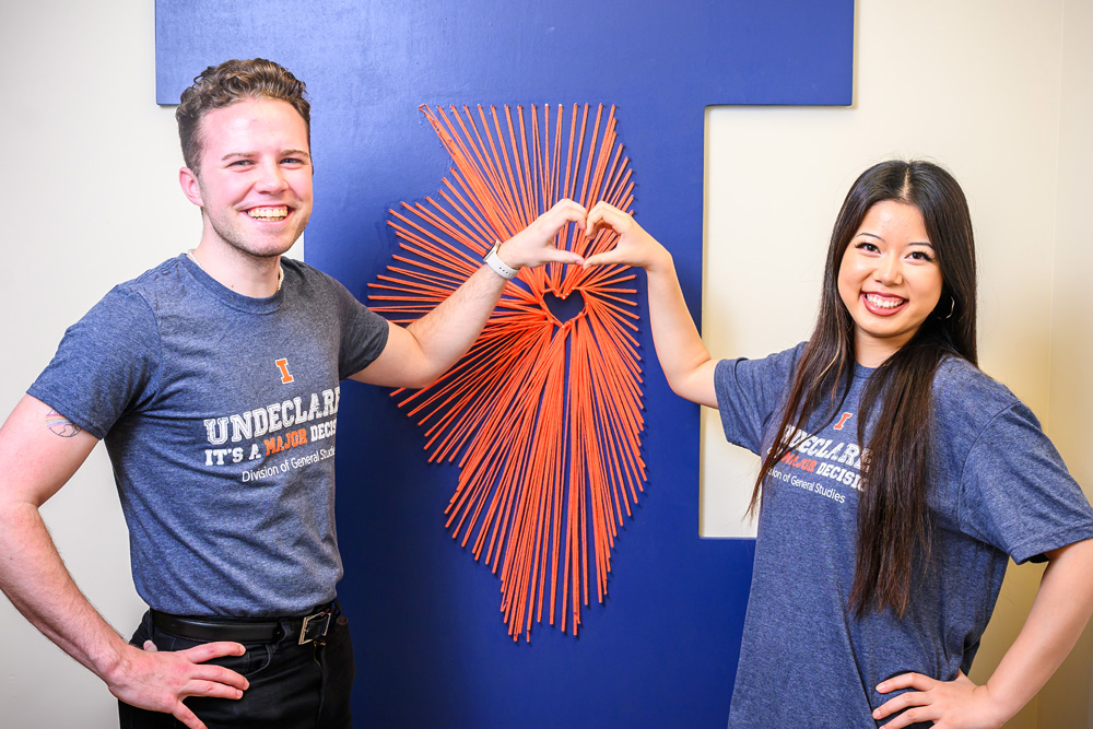 student of the Division of Exploratory Studies heart pose in front of Illinois string art in their Division's office