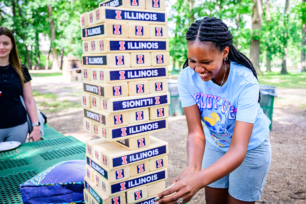 students and staff playing Jenga at summer fun afternoon picnic sponsored by International Education and ISSS
