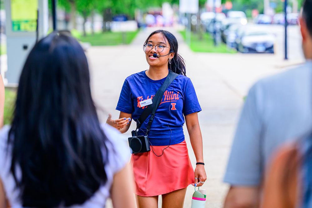 ISTAR wearing Fighting Illini shirt leads visiting parents and families on a campus tour