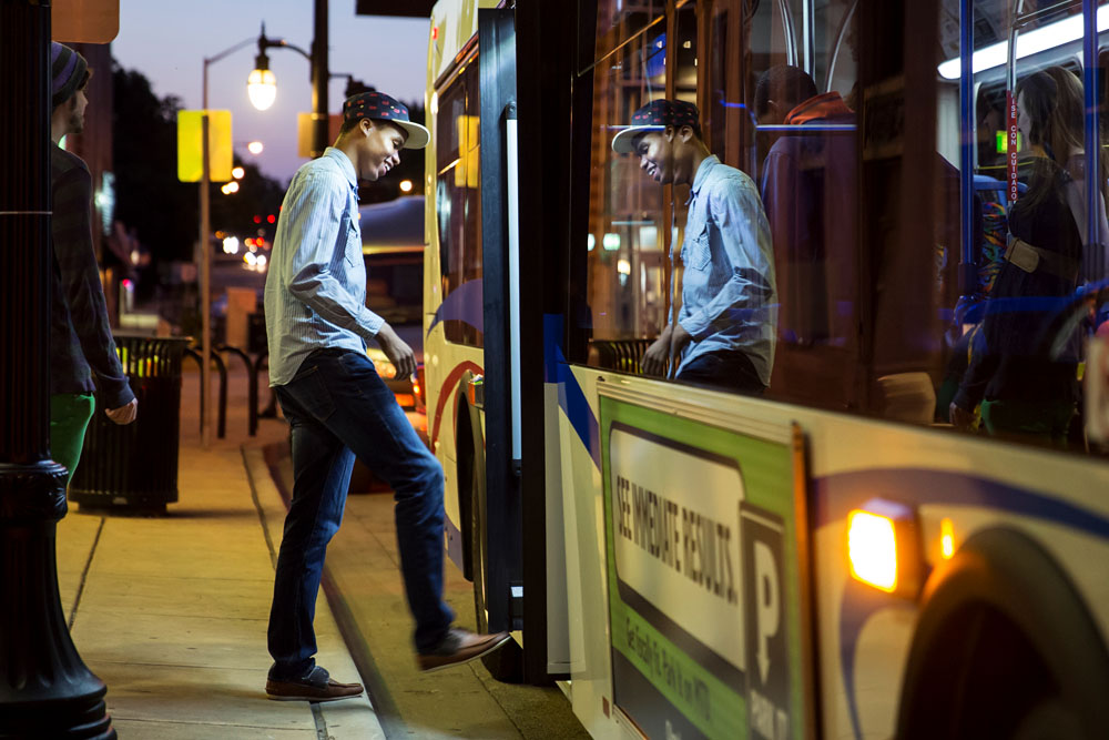 student getting on a campus MTD bus at night