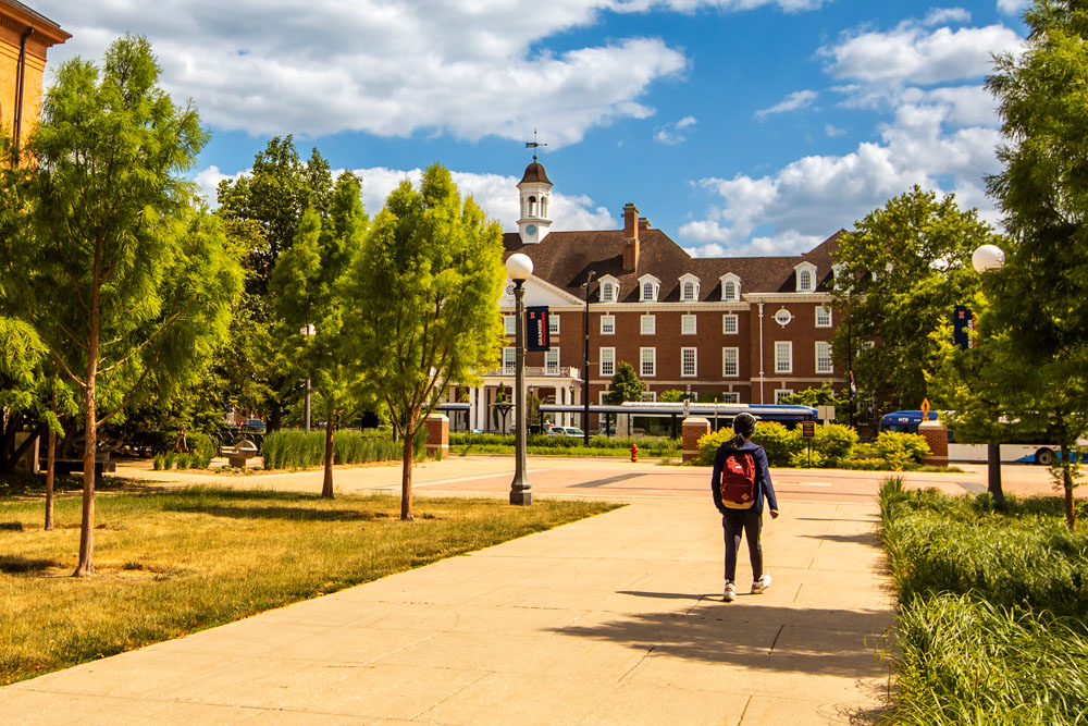 student explores quiet Illinois campus during the summer months, Illini Union in the background