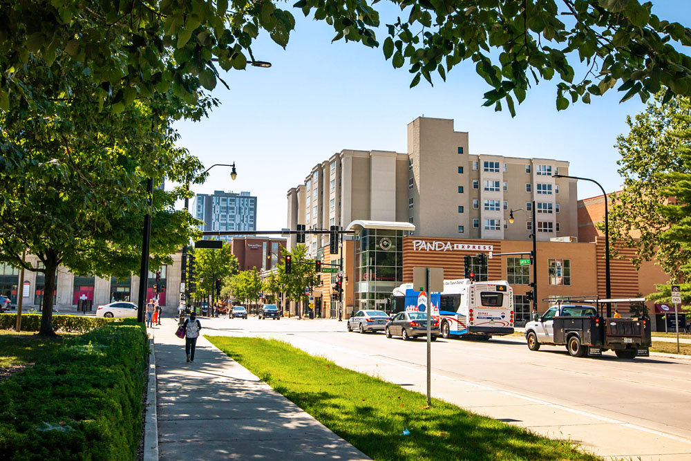 students, cars, and buses traverse the intersection of Green and Wright Streets
