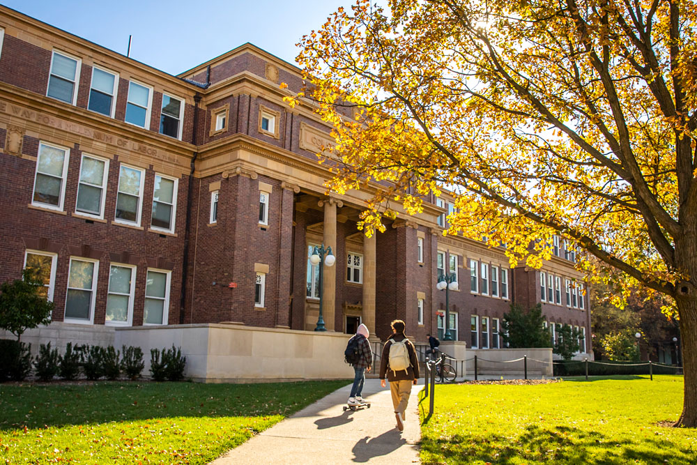 students entering Davenport Hall's entrance off the Quad on a fall day